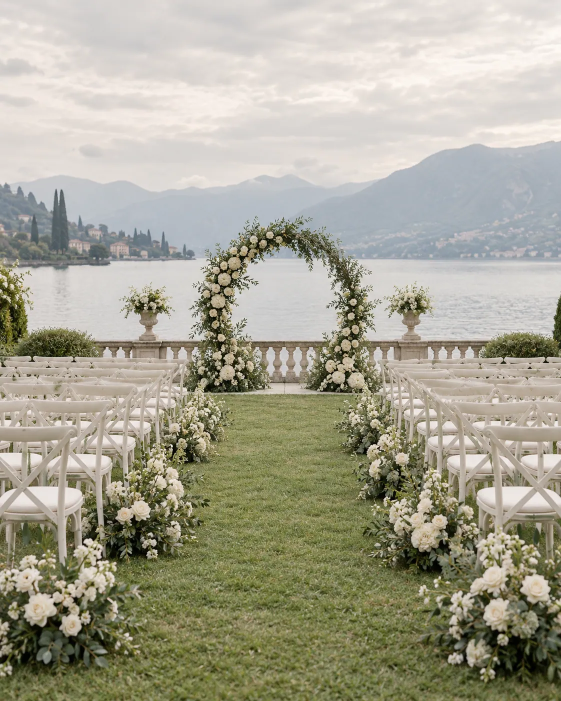 Sedie bianche e arco di fiori per una cerimonia in riva al lago